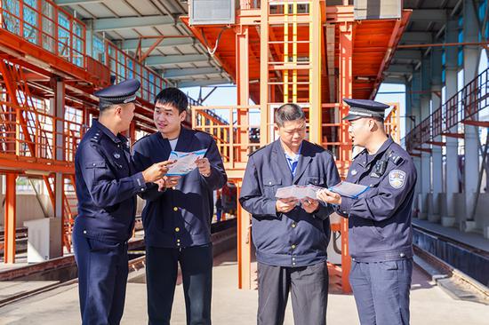 刑警支隊(duì)民警向企業(yè)職工發(fā)放宣傳資料并“一對(duì)一”講解電詐常識(shí)。謝仁古力·托呼提 攝